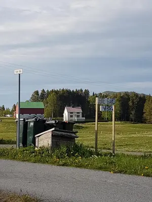 a sign on the side of a road next to a field at Leite Gård near Atlantic Road in Hustadvika in Lyngstad