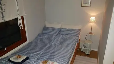 a bed with two cats sitting on top of it at Leite Gård near Atlantic Road in Hustadvika in Lyngstad