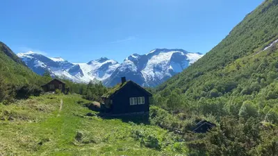 a house on a hill with mountains in the background at Stryn Hotel in Stryn