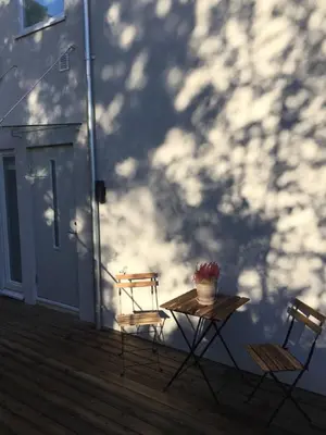 two chairs and a table on a porch with affect at Knudsen Apartment in Bergen