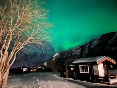 an image of the aurora borealis over a cabin at Trollstigen Resort in Åndalsnes