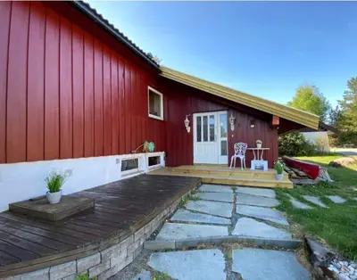 a red barn with a wooden deck in front of it at Bed and Breakfast Hadeland in Harestua