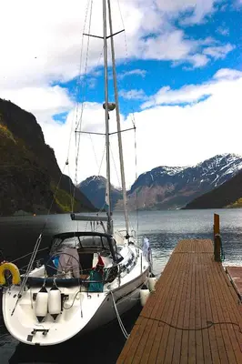 a boat is docked at a dock on the water at Flåm Marina in Flåm
