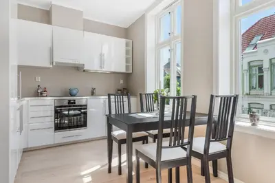 a kitchen with a black dining table and chairs at Fosswinckel Apartments in Bergen