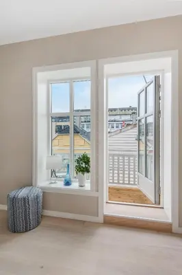 an empty room with two windows and a balcony at Fosswinckel Apartments in Bergen