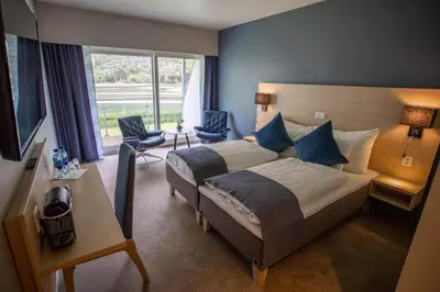 a bedroom with a bed and two chairs and a desk at Lærdal Hotel in Lærdalsøyri