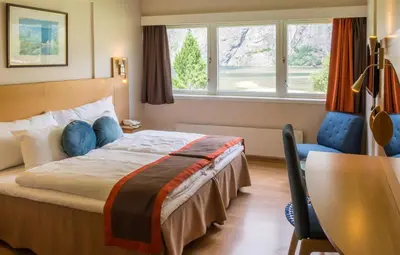 a hotel room with a bed and a desk and window at Lærdal Hotel in Lærdalsøyri