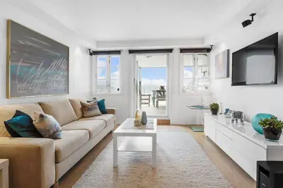 a living room with a couch and a tv at Øyjorden Apartment in Bergen