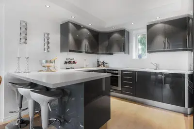 a kitchen with black cabinets and a white counter top at Øyjorden Apartment in Bergen