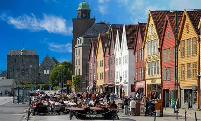 a group of people sitting at tables on a city street at Øyjorden Apartment in Bergen
