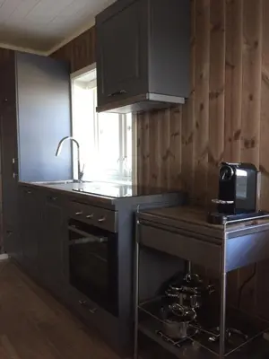 a kitchen with black cabinets and a sink at Norefjell Panorama in Noresund