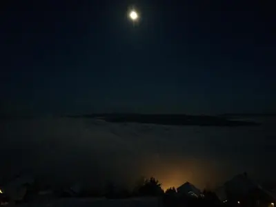 a full moon rising over the fog at night at Norefjell Panorama in Noresund