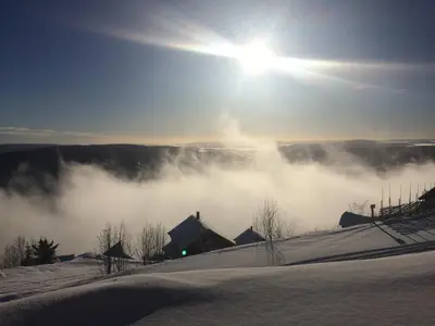a view of a snow covered hill with the sun in the sky at Norefjell Panorama in Noresund