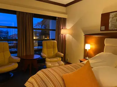 a hotel room with a bed and a table and chairs at Fitjar Fjordhotell in Fitjar