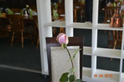 a pink rose in a vase on a chair at Fitjar Fjordhotell in Fitjar