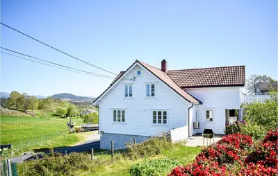a white house in a field with flowers at Lovely Home In Valevåg With Wifi in Valevåg