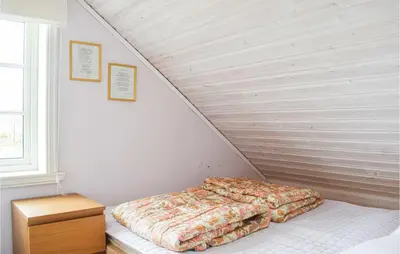 a bed in a room next to a staircase at Lovely Home In Valevåg With Wifi in Valevåg