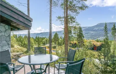 a table and chairs on a deck with a view at Lovely Home In Hemsedal With Sauna in Hemsedal