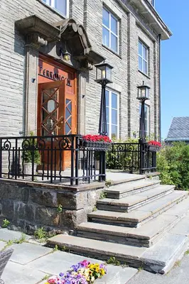 a building with stairs leading to a door with flowers at Oppdal Turisthotell in Oppdal
