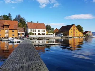 a dock in a town with houses on the water at Rugsund Handelsstad in Rugsund