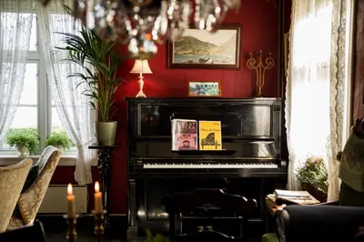 a black piano in a room with red walls at Walaker Hotel in Solvorn