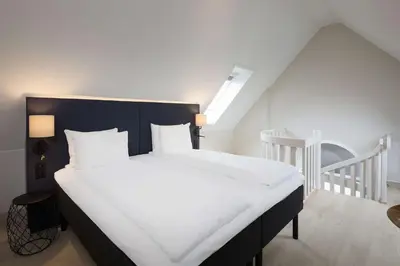 a bedroom with a large bed with white sheets at Scandic Torget Bergen in Bergen