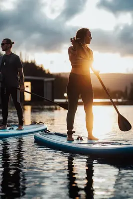 a man and a woman on paddle boards in the water at Gaustablikk Fjellresort in Gaustablikk