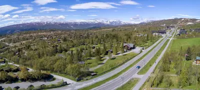 an aerial view of a road with mountains in the background at Knuts Hyttegrend in Beitostøl