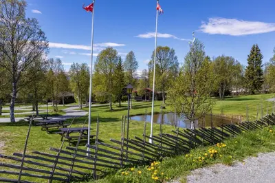 a group of benches in a park with a pond at Knuts Hyttegrend in Beitostøl