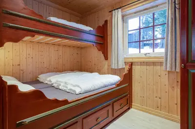 a bedroom with two bunk beds in a cabin at Knuts Hyttegrend in Beitostøl