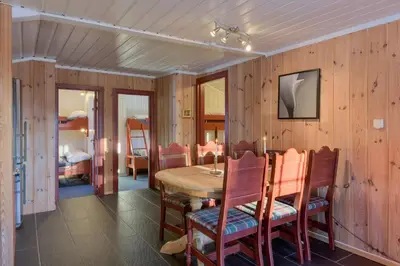 a dining room with a table and chairs and a bedroom at Knuts Hyttegrend in Beitostøl