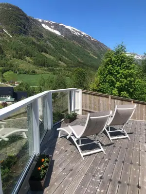 a deck with two chairs and a table on it at Jølster Holiday home in Skei