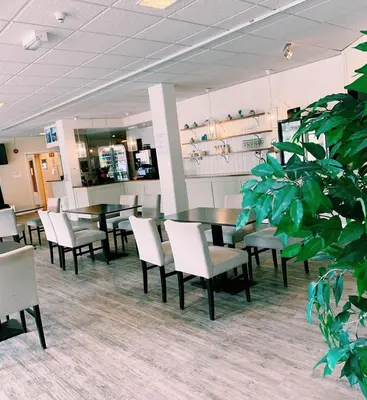 a dining room with tables and chairs and a plant at Rødberg Hotel in Rødberg