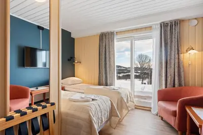 a hotel room with two beds and a window at Grønolen Fjellgard in Beitostøl