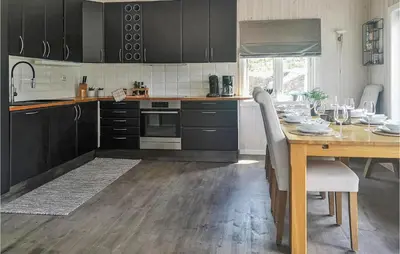 a kitchen with a wooden table and a dining room at Stunning Home In Hebnes With Kitchen in Hebnes