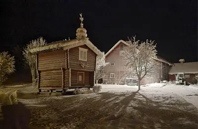 a small wooden building with a cross on top at Bakken Gårdshus in Rendalen