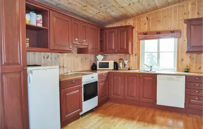 a kitchen with wooden cabinets and white appliances at Sjusjøen Pihl 185 in Sjusjøen