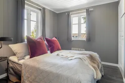 a bedroom with a bed and a couch and windows at Villa Heidi - 30 min fra OSL - Jacuzzi - Badstu - Elbillader in Ulven
