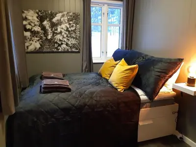 a bedroom with a bed with pillows and a window at Villa Heidi - 30 min fra OSL - Jacuzzi - Badstu - Elbillader in Ulven