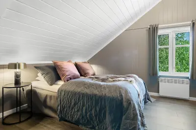 a bedroom with a bed and a white ceiling at Villa Heidi - 30 min fra OSL - Jacuzzi - Badstu - Elbillader in Ulven