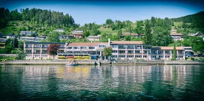 a large building on the shore of a body of water at Strand Fjordhotel in Ulvik