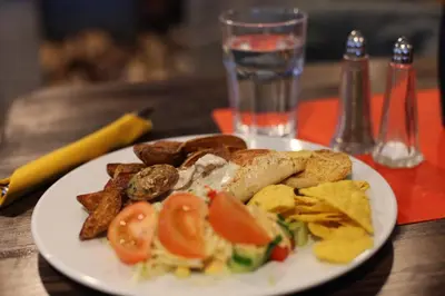a white plate of food on a wooden table at Hordatun Hotel in Røldal