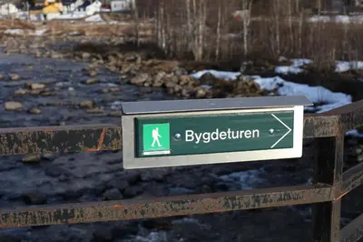 a sign on a wooden fence with a sign for the abbreviation at Hordatun Hotel in Røldal