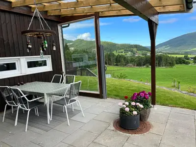 a patio with a table and chairs and a view at Family Room in Modern House in Eide