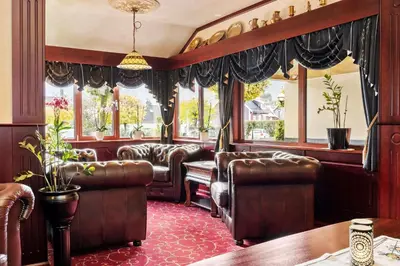 a bar with leather chairs and tables and windows at Best Western Laegreid Hotell in Sogndal