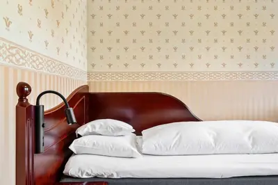 a bed with a wooden headboard and two pillows at Best Western Laegreid Hotell in Sogndal