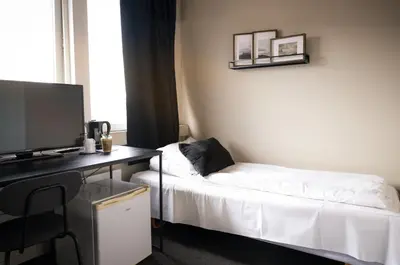 a room with a desk with a computer and a bed at Ågotnes Motell in Ågotnes