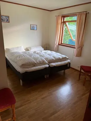 a large bed in a room with a window at Der Fjordtraum in Balestrand direkt am Wasser in Balestrand