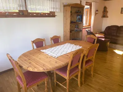 a wooden table with chairs around it in a living room at Der Fjordtraum in Balestrand direkt am Wasser in Balestrand