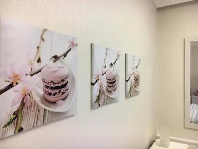 a wall with three pictures of a cake and three paintings at Kirkegata 4 in Ålesund